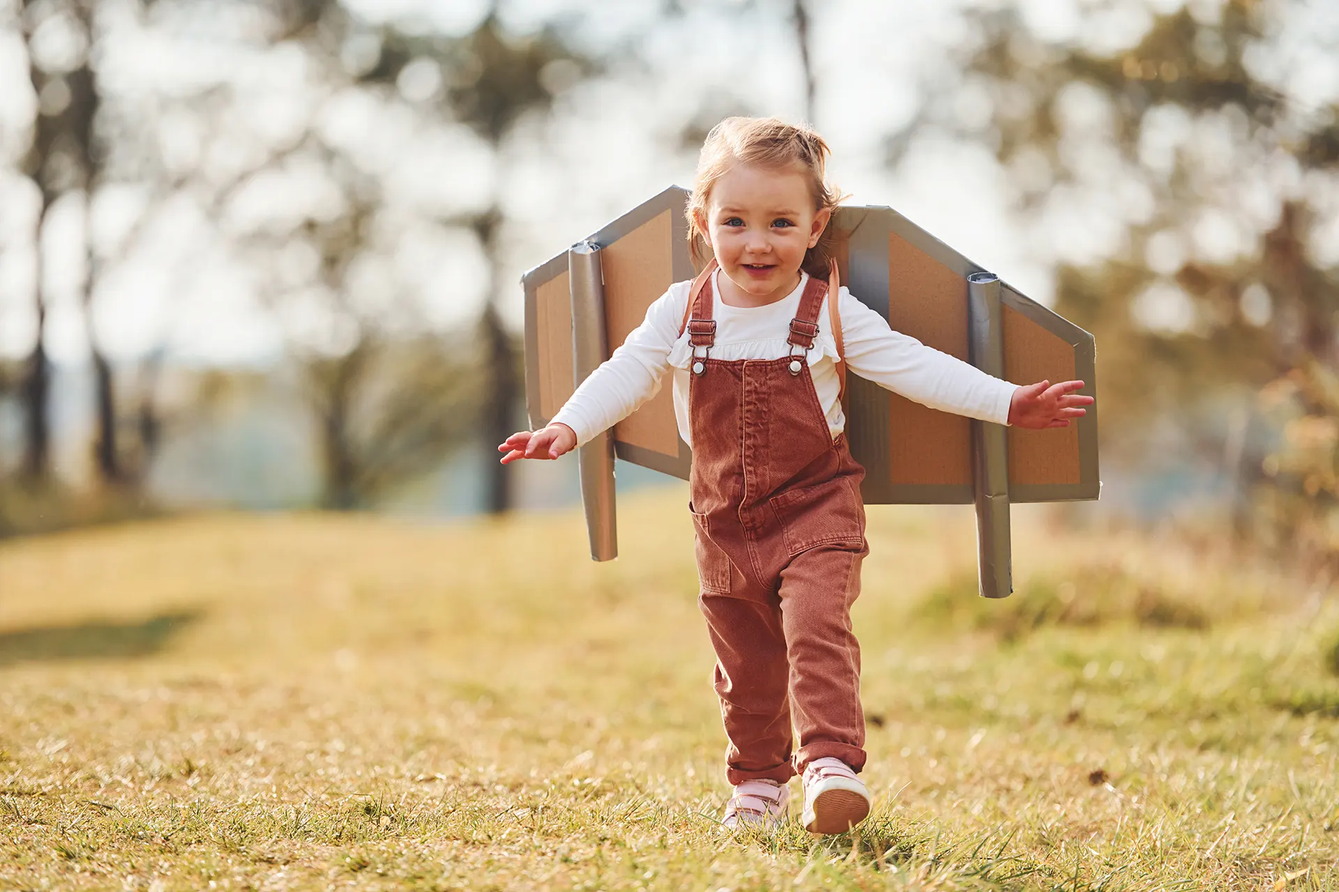 cute-little-girl-with-handmaded-wings-running-outdoors-field-having-fun copy